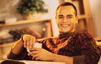 Obrázek mladý muž s úsměvem, držící šálek kávy